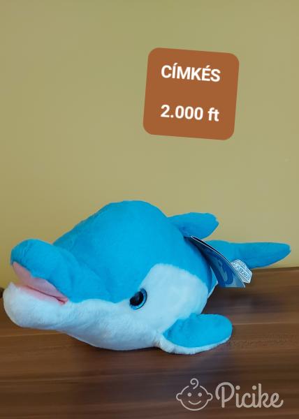 Kék plüss delfin címkével